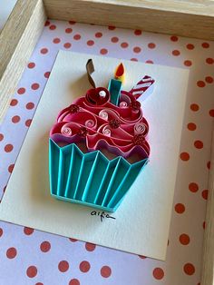 a paper cupcake with a candle on it