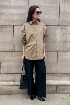 Oversized tailored shirt with drop shoulder. Box center pleat at back, with rounded hem and extended tail. Shell buttons. Oversized fit. Wear your normal size for an oversized fit or size down for a more traditional fit. Model is wearing an XS. 100% cotton. Gentle machine wash cold, inside out, with like colors. Lay flat to dry. Oversized Shirt With Shirttail Hem For Work, Oversized Solid Shirt For Workwear, Oversized Workwear Shirt, Oversized Solid Shirt With Shirttail Hem, Oversized Shirt With Shirttail Hem, Oversized Straight Hem Tops For Work, Oversized Solid Shirt With Button Cuffs, Oversized Tops For Workwear With Straight Hem, Oversized Tops With Straight Hem For Work