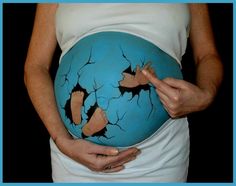 a pregnant woman holding a blue ball with holes in it's belly and hands