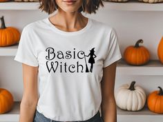 a woman wearing a basic white t - shirt with the words basic witch printed on it