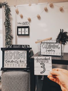 a person is holding up some signs in front of a desk with writing on it