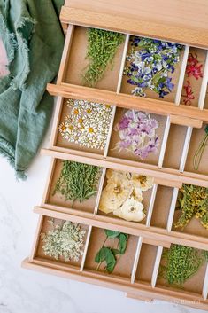 an open wooden box filled with flowers and herbs