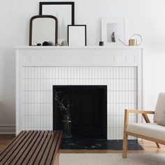 a living room with a white fireplace and pictures on the mantle