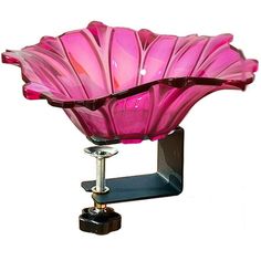 a pink glass bowl sitting on top of a metal stand