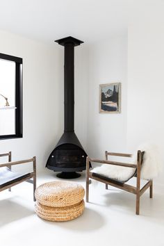 a living room filled with furniture and a wood burning stove in the middle of it