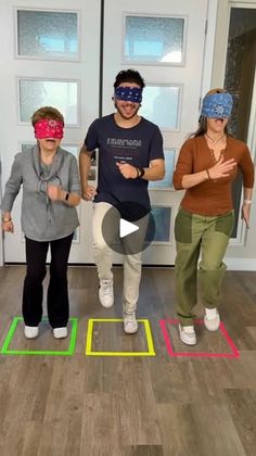 three people wearing blindfolds standing in front of a door