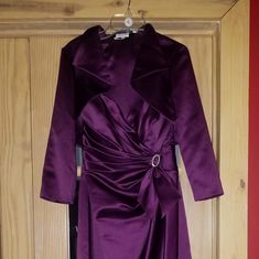 a purple robe hanging on a wooden door