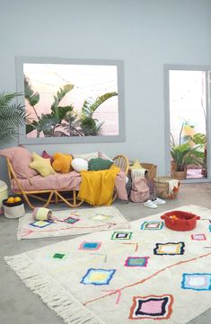 a living room filled with lots of furniture and rugs on top of a floor