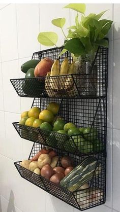 three tiered metal fruit and vegetable rack on the wall next to a tiled wall