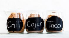 three jars with chalk writing on them that say chill cajun and chili taco