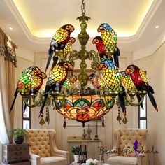 a chandelier hanging from the ceiling in a living room filled with furniture and decor