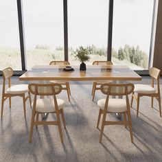 a table with chairs and a vase on it in front of large windows overlooking an open field