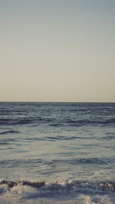 an ocean view with waves coming in to shore