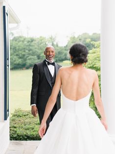 the bride and groom are standing outside in their tuxedo attire, looking at each other