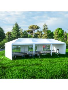 a white tent set up in the middle of a field