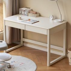 a white desk with a lamp on top of it in a room next to a window