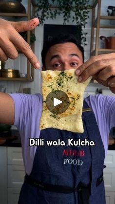 a man holding up a piece of food in front of his face with the words dilli wala kulcha on it