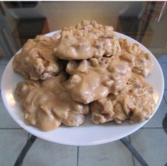 a plate full of cookies covered in caramel icing on a tile counter top