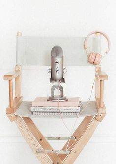 a microphone sitting on top of a wooden stand with headphones hanging from it's sides