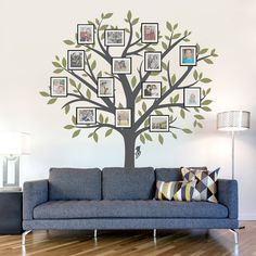 a living room with a blue couch and a tree wall decal on the wall