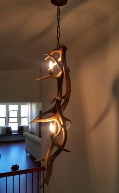 a chandelier made out of deer antlers hanging from the ceiling in a living room