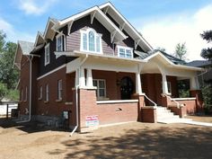 a large brick house with white trim on the front and side of it's windows