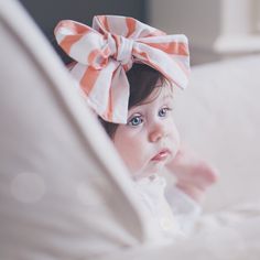 a baby girl with a big bow on her head