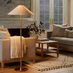 a living room with two couches and a lamp on the table next to it