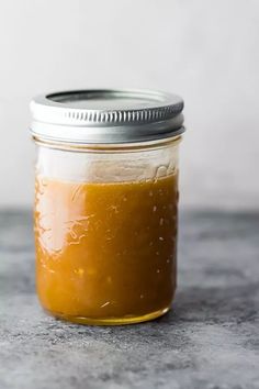 a jar filled with yellow liquid sitting on top of a table