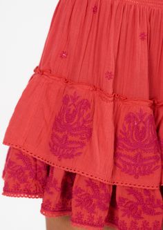 Get ready to turn heads in our Mina Embroidered Mini Skirt! With its bright coral hue and stunning embroidery detailing, this skirt is perfect for dressing up or down. The button front and tiered design add a playful touch and the lightweight linen cotton blend makes it a comfortable choice. Plus, it even has side pockets for added convenience! Pink Embroidered Bohemian Skirt, Bohemian Pink Embroidered Skirt, Summer Long Skirt With Embroidered Hem, Red Tiered Skirt For Summer, Summer Floral Embroidery Tiered Skirt, Traditional Ruffled Skirt For Summer, Traditional Summer Dress With Tiered Skirt, Traditional Tiered Skirt Dress For Spring, Traditional Spring Dresses With Tiered Skirt