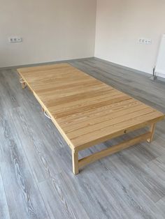 a wooden table sitting on top of a hard wood floor next to a radiator