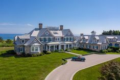 an aerial view of a large house with a car parked in the driveway and lots of grass