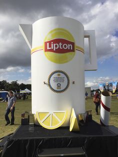 a giant cup shaped like a lemon sits on top of a table in the middle of a field