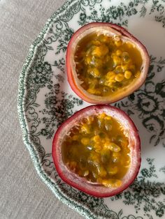 two halves of pomegranate sitting on top of a white and green plate