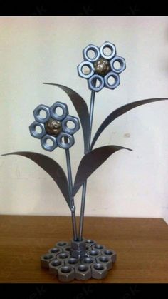 a metal flower sculpture sitting on top of a wooden table