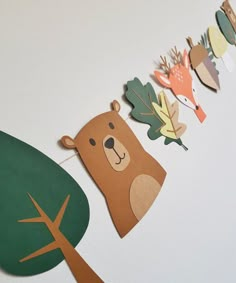 paper animals and leaves are hanging on the wall next to a bear banner that says forest