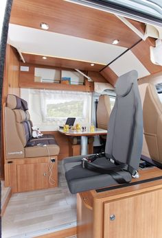 an interior view of a motor home with wood paneling and leather seats in the foreground