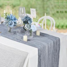 the table is set with blue flowers and candles