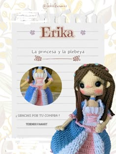 the crocheted doll is wearing a blue and white dress with pink trims