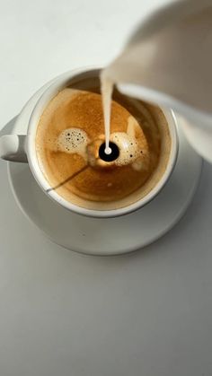 a cup of coffee is being poured into it