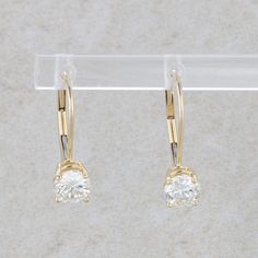 This pair of earrings are 14k yellow gold and they have two round brilliant diamonds that are prong set. These diamonds measure 1.00cttw, with one having a color and clarity of L/SI2 and the other having a color and clarity of M/SI2. The earrings measure 5.0mm wide and 14.0 mm tall. They weigh 1.23 grams. Condition: Pre-Owned *All items are thoroughly inspected for quality assurance purposes Classic Hoop Earrings With Single Round Cut Diamond, Fine Yellow Gold Diamond Earrings With Lever Back, Formal Single Diamond Huggie Earrings, Formal Huggie Earrings With Single Diamond, Formal Single Diamond Hoop Earrings, Classic 14k Gold Hoop Earrings With Single Diamond, Classic Yellow Gold Hoop Earrings With Single Diamond, Classic Hoop Earrings With Single Diamond, Classic 14k Gold Hoop Earrings With Brilliant Cut