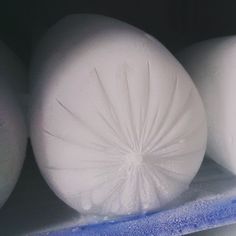 three white eggs sitting next to each other on a shelf