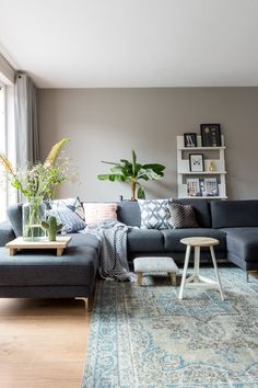 a living room filled with furniture and a large rug on top of a hard wood floor