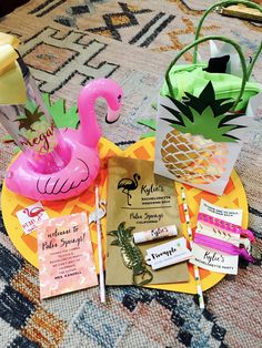 various items are arranged on a table for a tropical bridal party with flamingos and pineapples