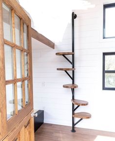 a spiral staircase in the corner of a room with wood flooring and white walls