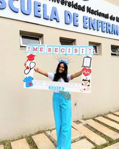 a woman holding up a sign in front of a building