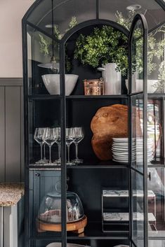 a glass cabinet with plates and glasses on it