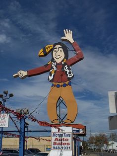 a large statue of a man on top of a sign in front of a building