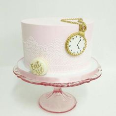 a pink cake with a gold clock on top