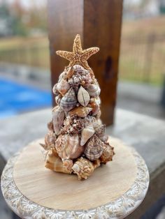 a small christmas tree made out of seashells and starfish on a table